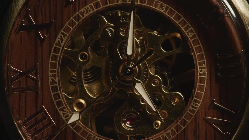 A clocks hands turn as the gears rotate behind them