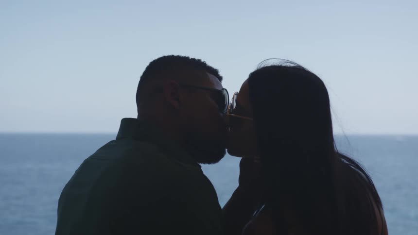 A couple kissing in front of the ocean