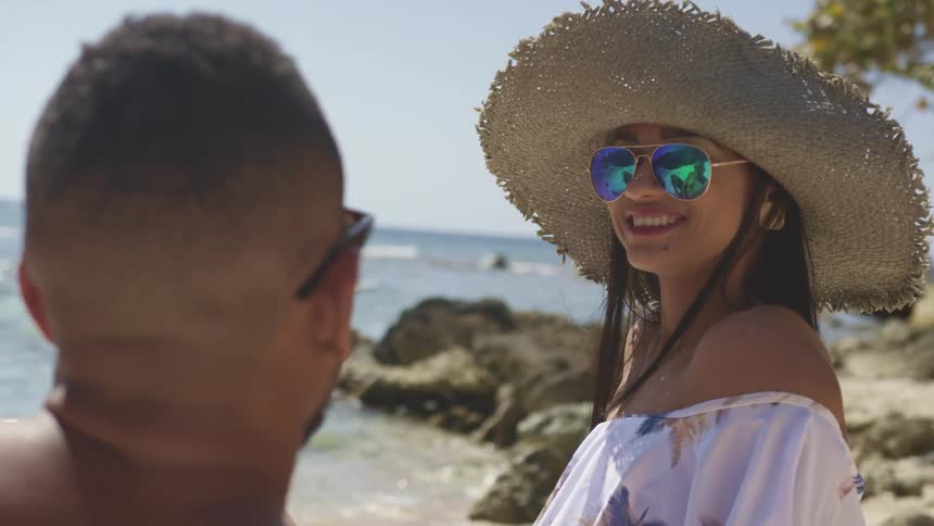A young couple relaxes together on the beach on a sunny day