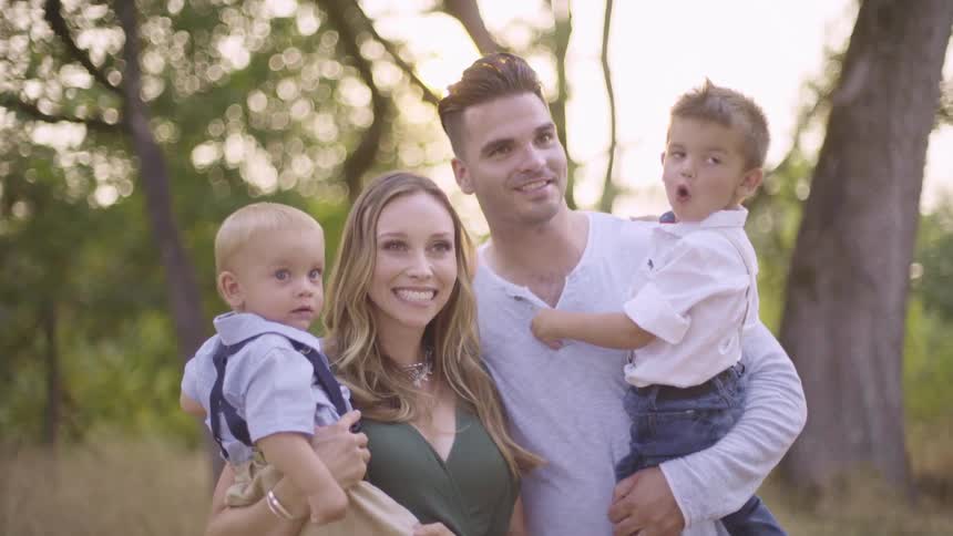 Parents hold their children near the forest