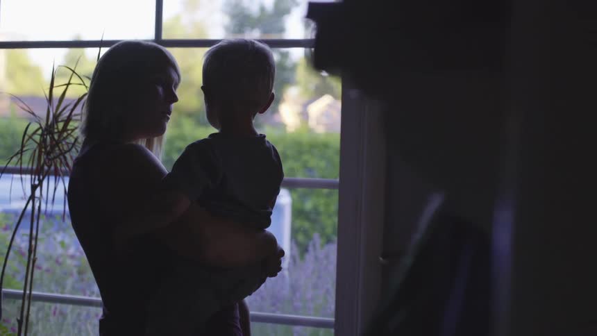 Mother and daughter looking out a window