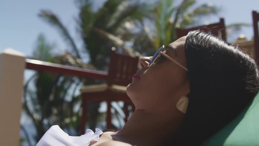 A teenage girl lies outside and suntans