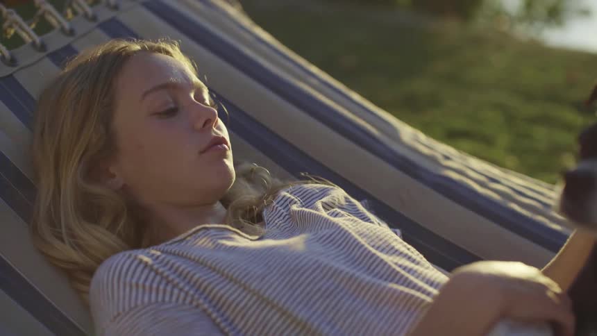 A teenager laying on a hammock