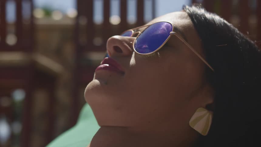 A teenage girl lies outside in the sun