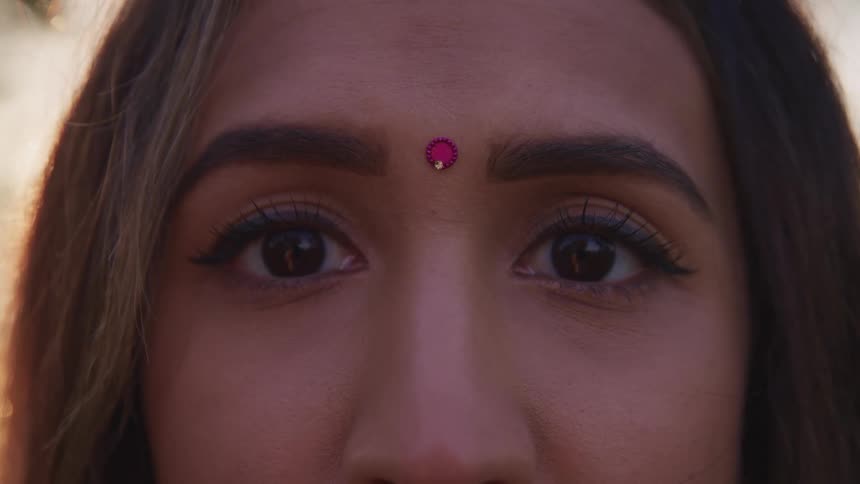 Close up of the bindi on the forehead of a woman outdoors