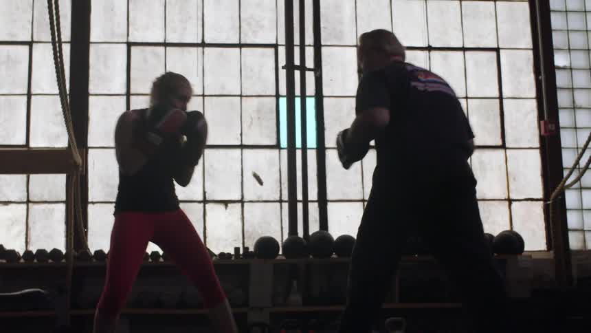 Man and woman spar in a fitness room