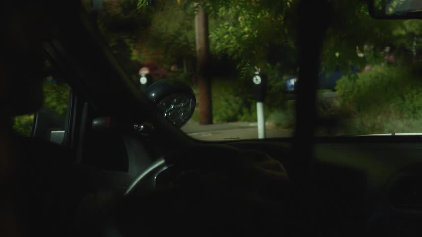 A man backs his car out of a parking spot