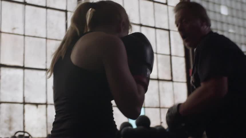 Man and woman practice boxing in a fitness room