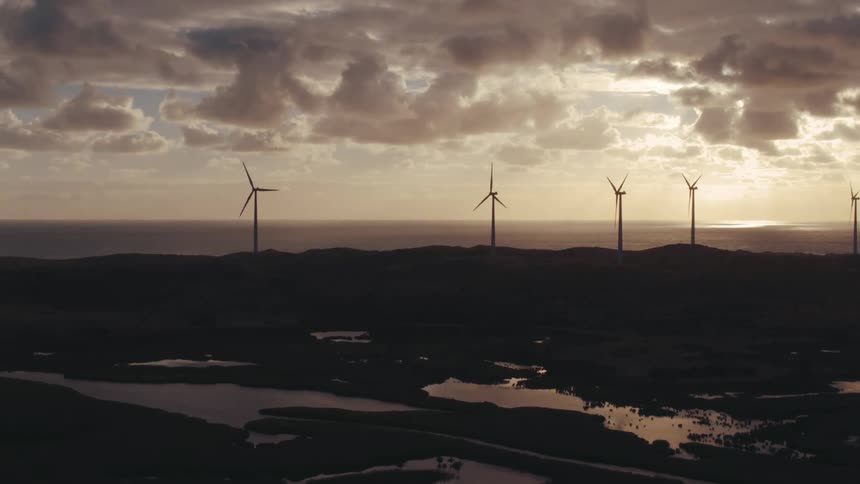 Wind turbines spinning on wind farm on cloudy day
