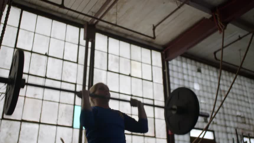 A woman is lifting weights in a gym