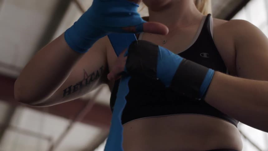 A woman wraps blue cloth around her arm