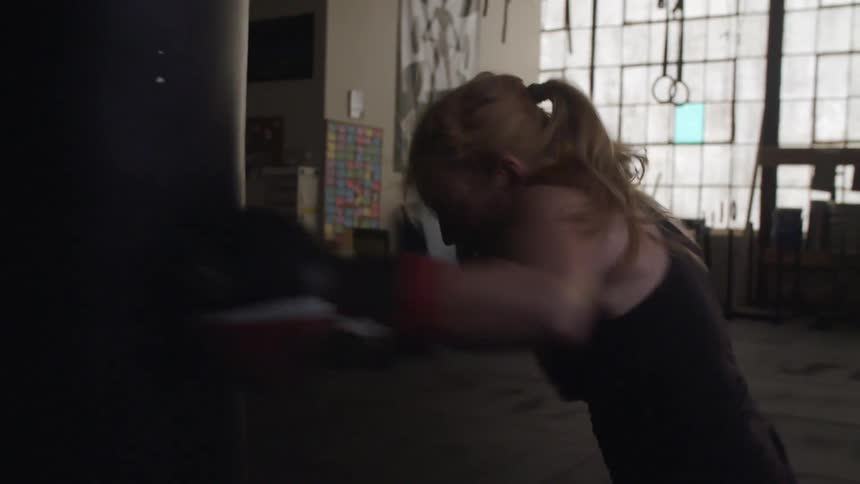 A woman hits a punching bag