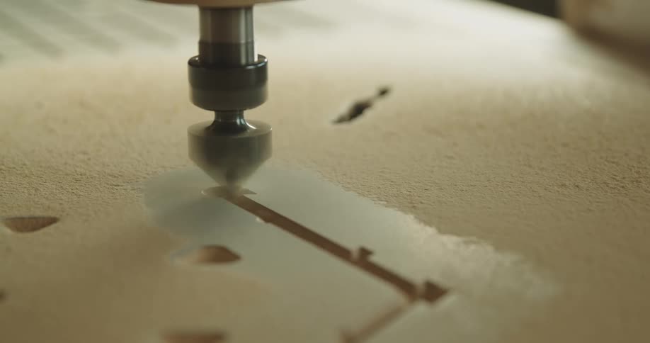 A rapidly rotating tip of a wood etching machine carves a design with high precision
