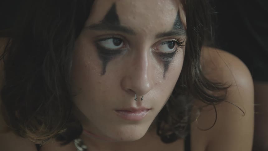Close up of a womans face wearing an harlequim makeup