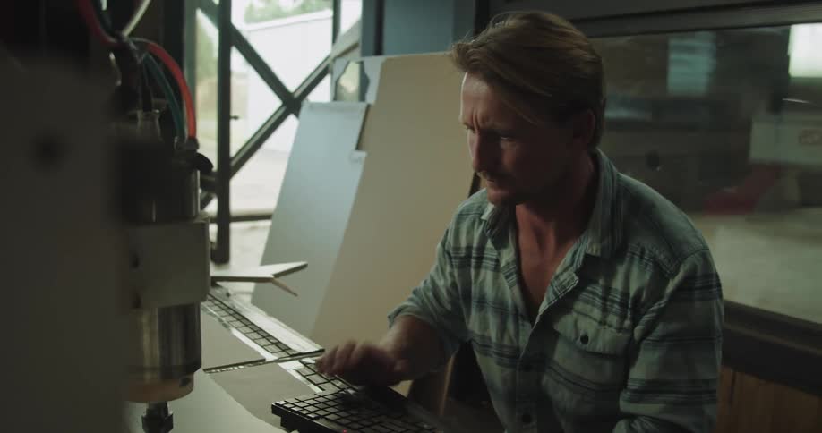 A man is working with a machine and marks an area on the surface in front of him