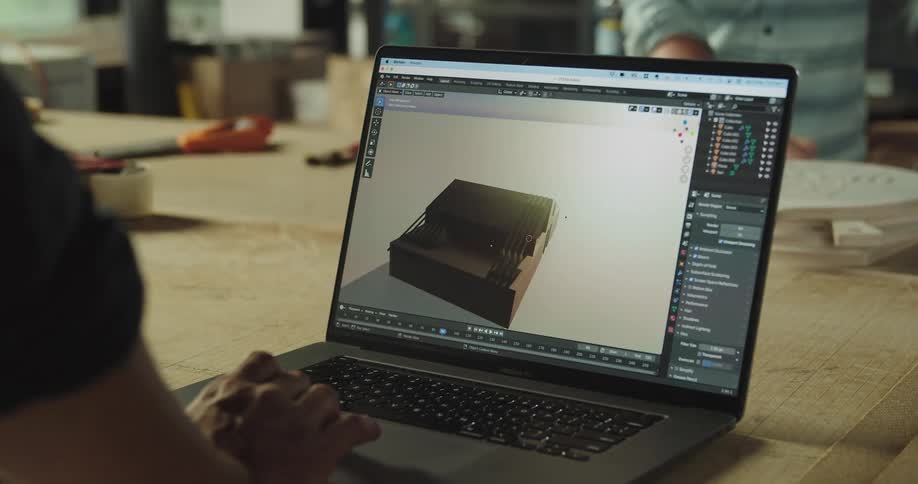 A man inspects a 3D model on a laptop