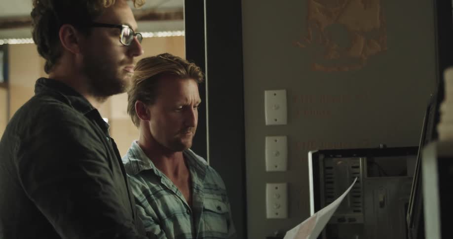 Two men looking at a piece of paper