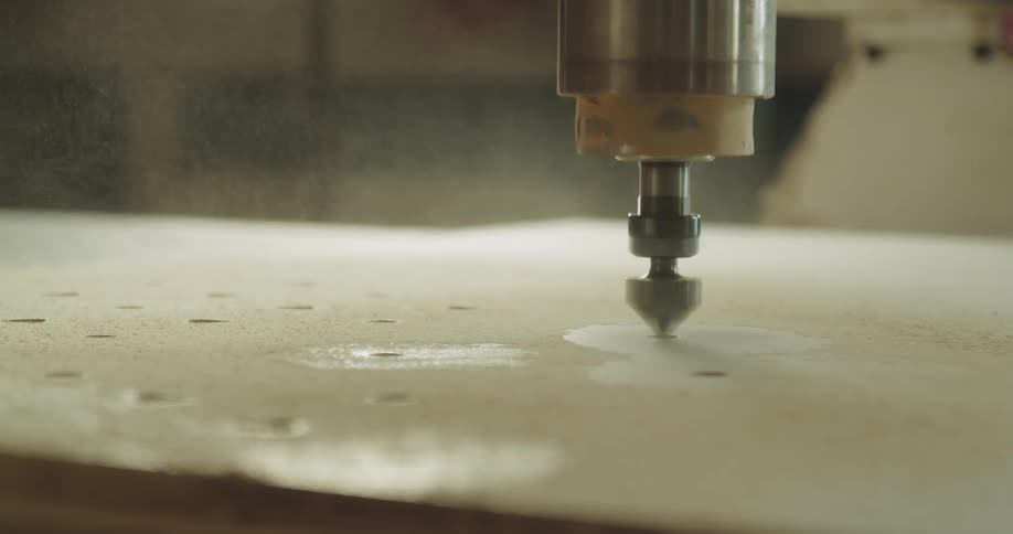 A drill drilling holes in wood in a factory