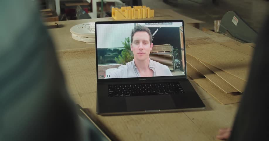 A man having a video call through a laptop with coworkers