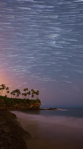 Time lapse of stars moving over a beach