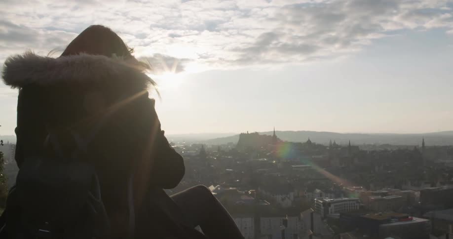 A woman looks out over a town on a windy day