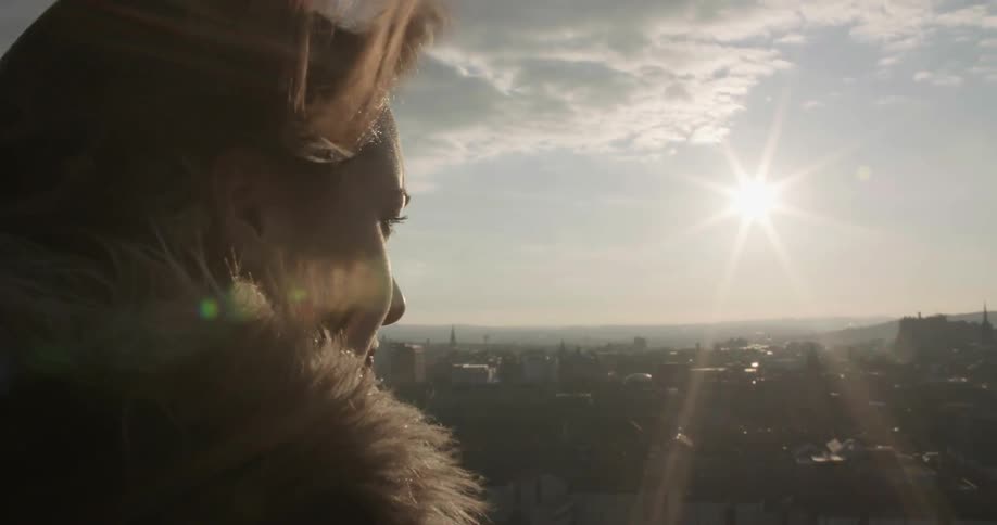 Woman looking out at a city on a very windy day