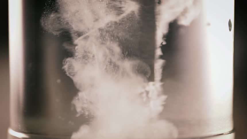 White powder drops into a beaker