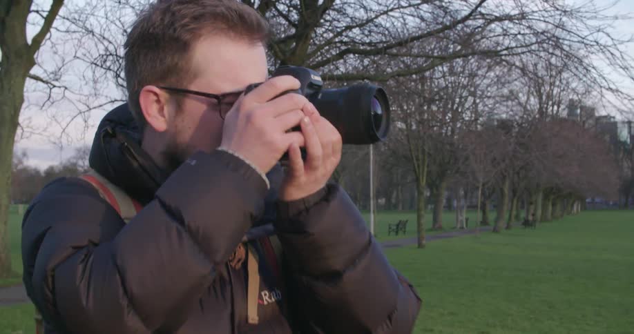 Man outside holding a camera up to his face