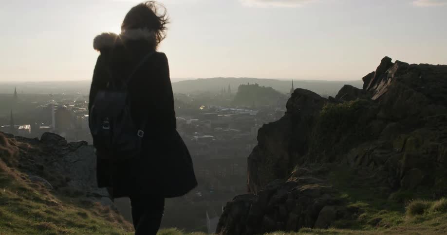 A woman walks down a path on a windy day
