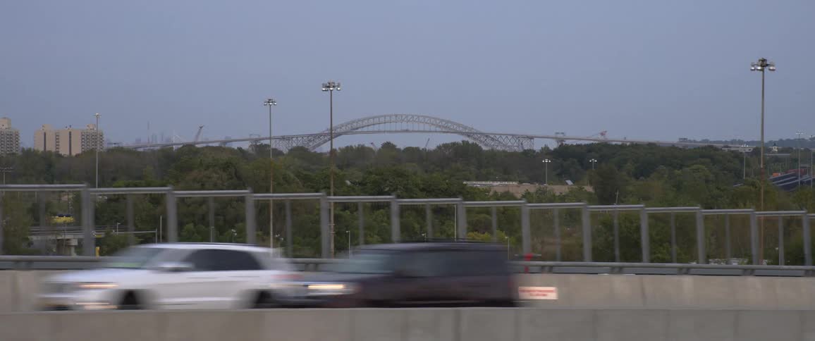 A highways with cars and traffic with a bridge in the background