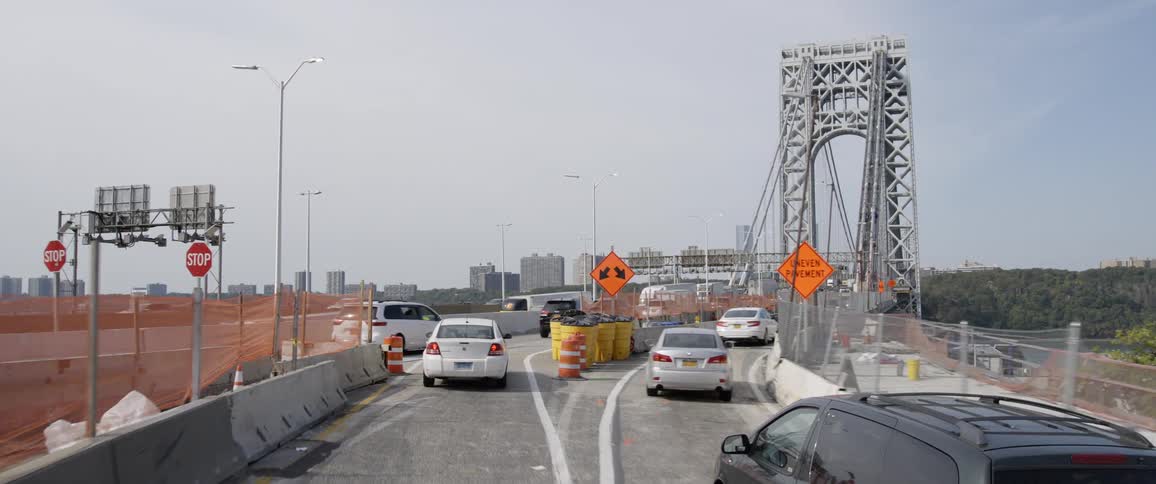 Vehicles driving across a bridge in to a city