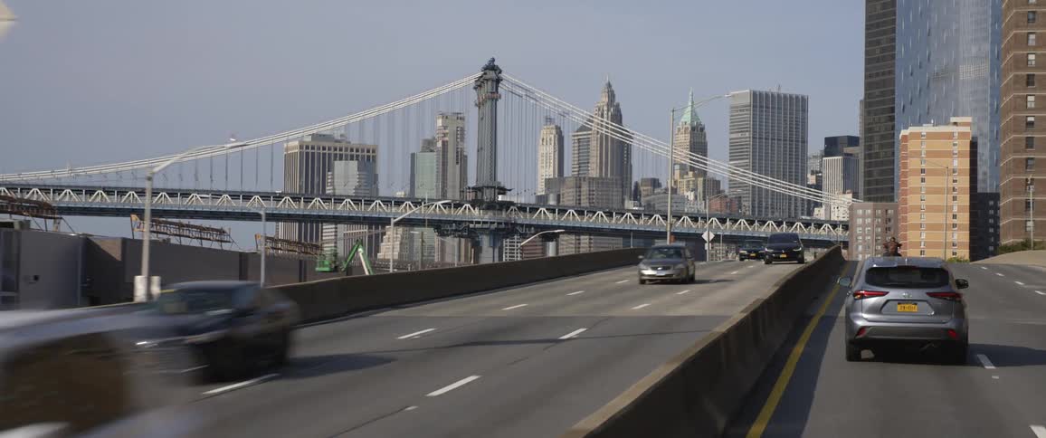 Highway with traffic with a skyline of buildings and a bridge in daylight