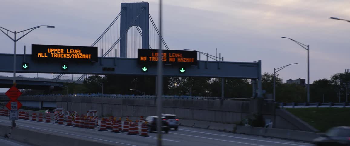 Vehicles travel together on the highway by the bridge
