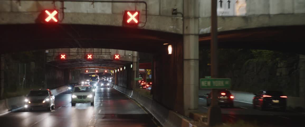 Vehicles driving under bridges and overpasses on a highway on the city at night