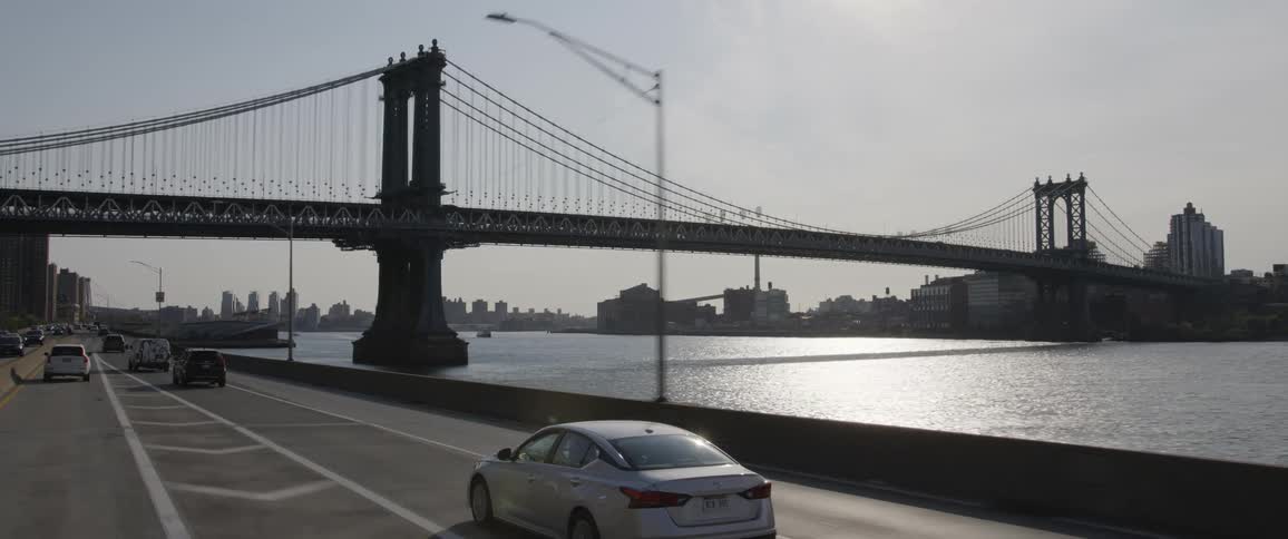 A panning shot of a city skyline with a bridge
