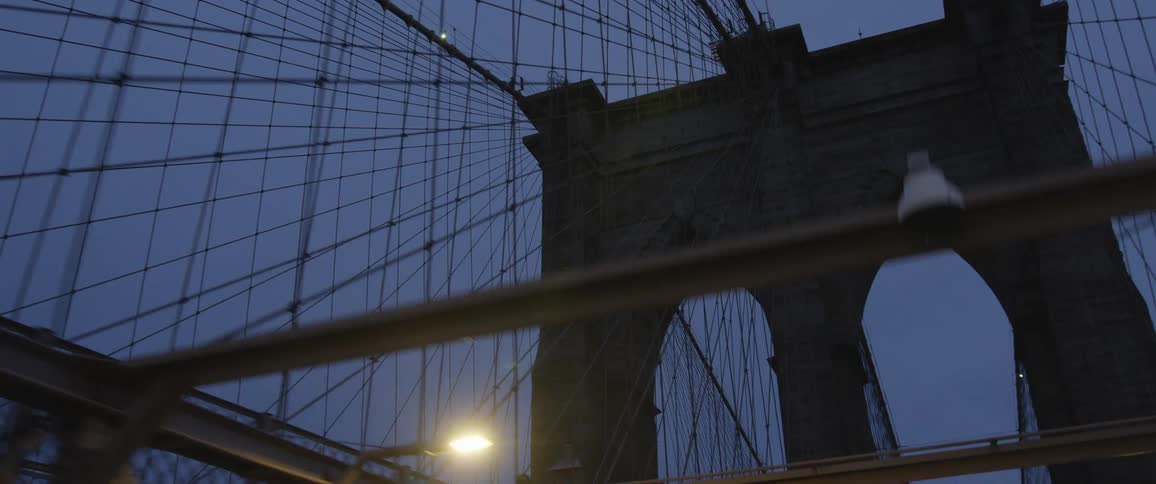 An american flag waves in the wind ontop of a bridge