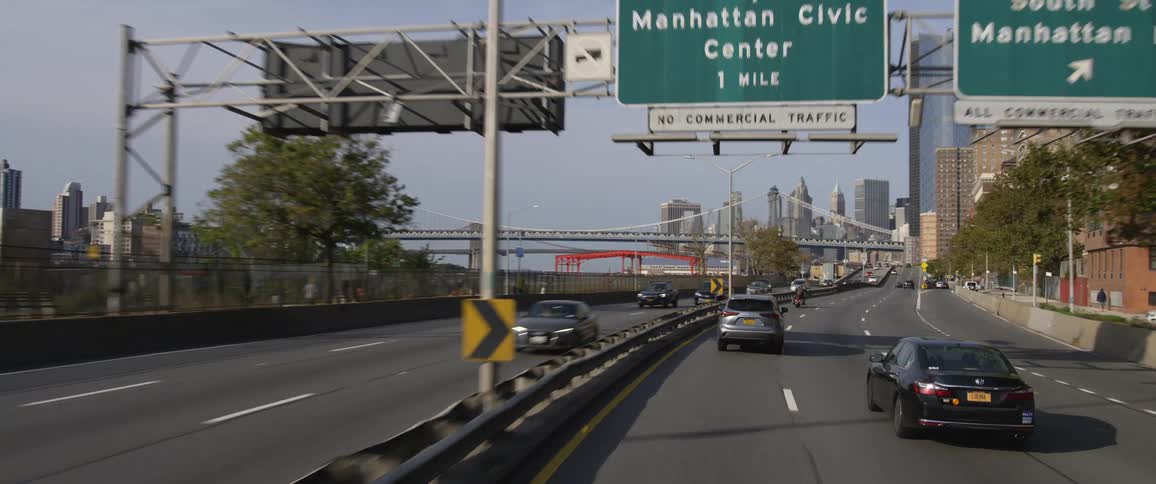 Cars are driving on a highway near a city