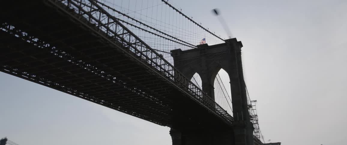Vehicle drives under the brooklyn bridge on the highway