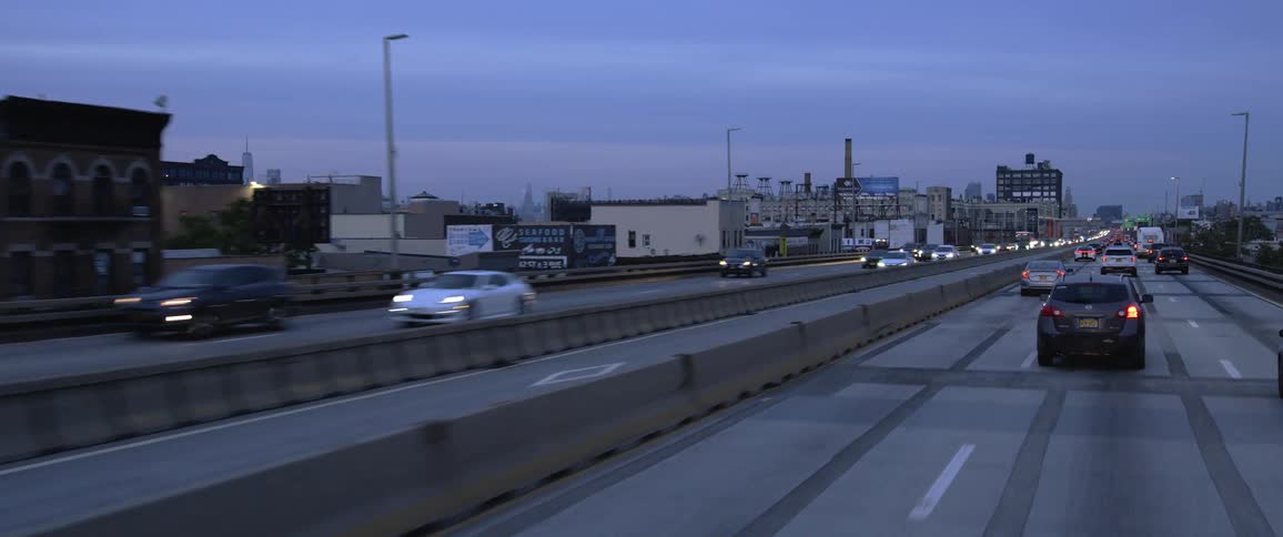 A black car moves through traffic on the highway