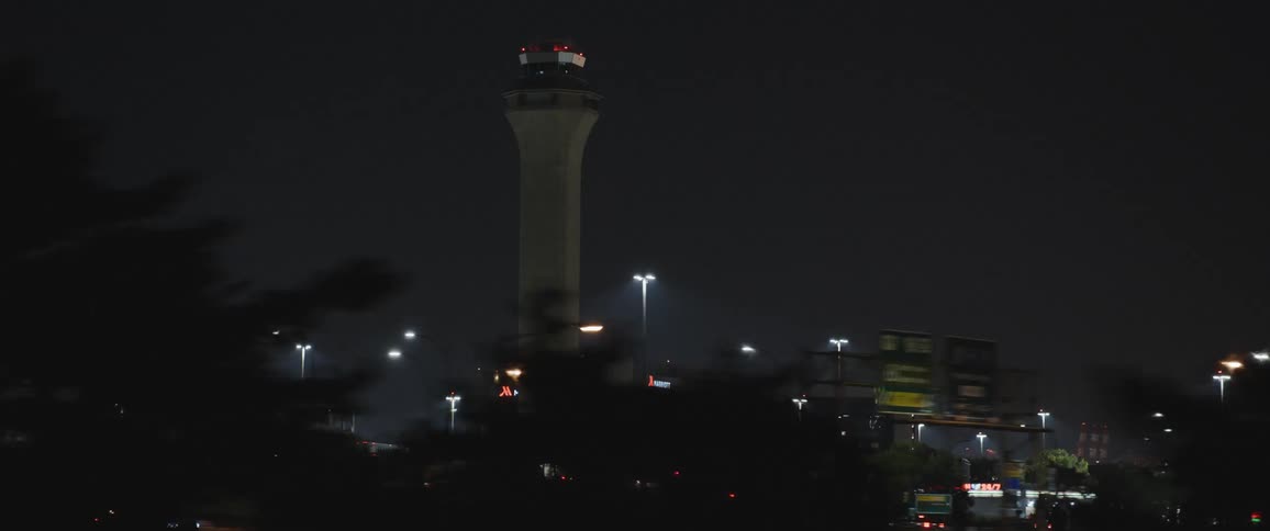 Air traffic control tower in a urban area at night