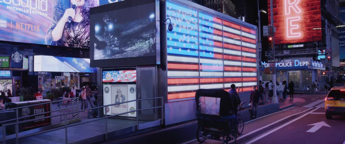 Downtown street with buildings lights video display and people at night