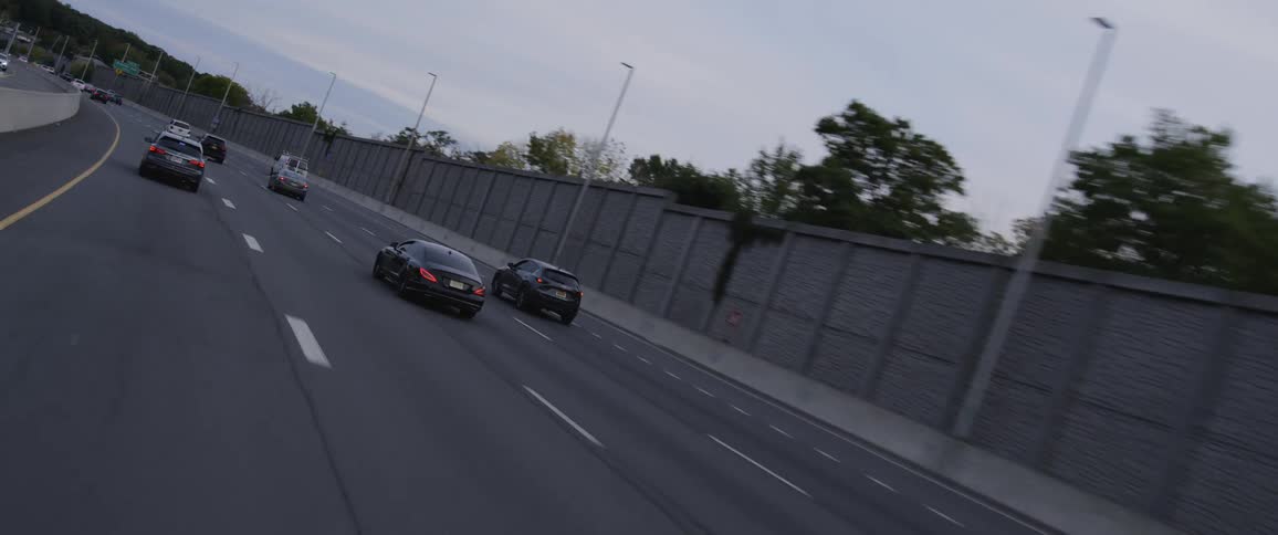 Traffic travels along a freeway on a cloudy evening