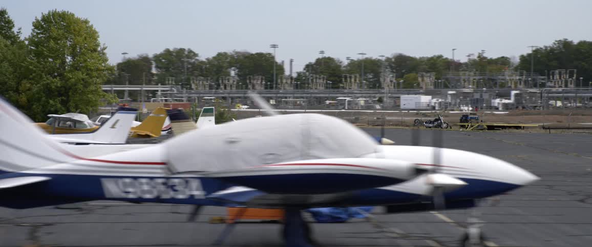 A parking lot near many buildings is full of small planes