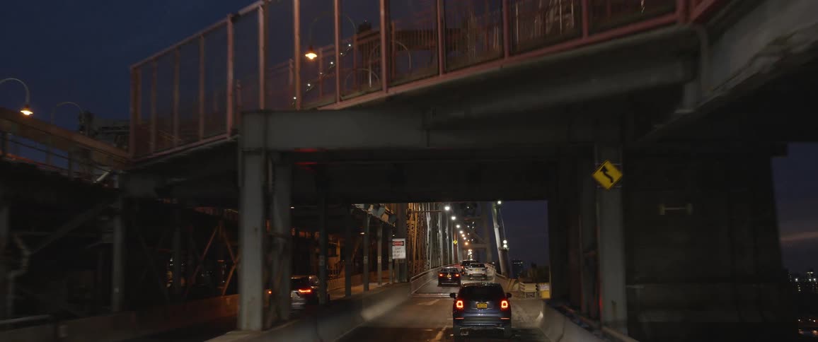 Vehicles driving on a bridge in a city at night