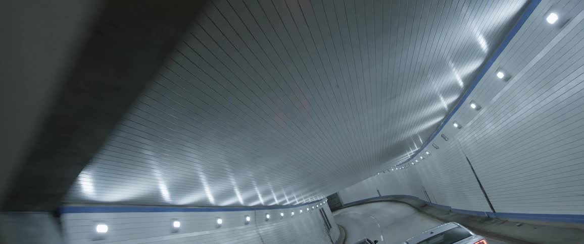 Cars drive into a tunnel filled with lights