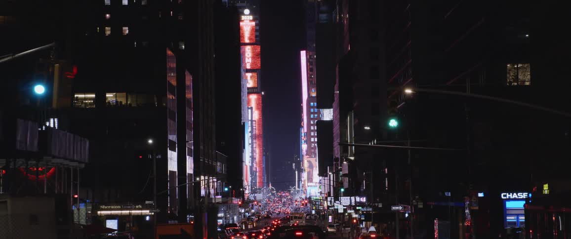 Traffic lines a busy downtown street with lit up buildings