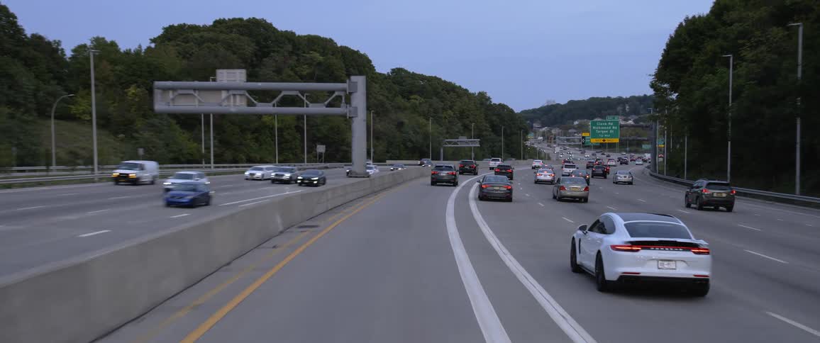 Vehicles and traffic ona highway with trees surrounding the area