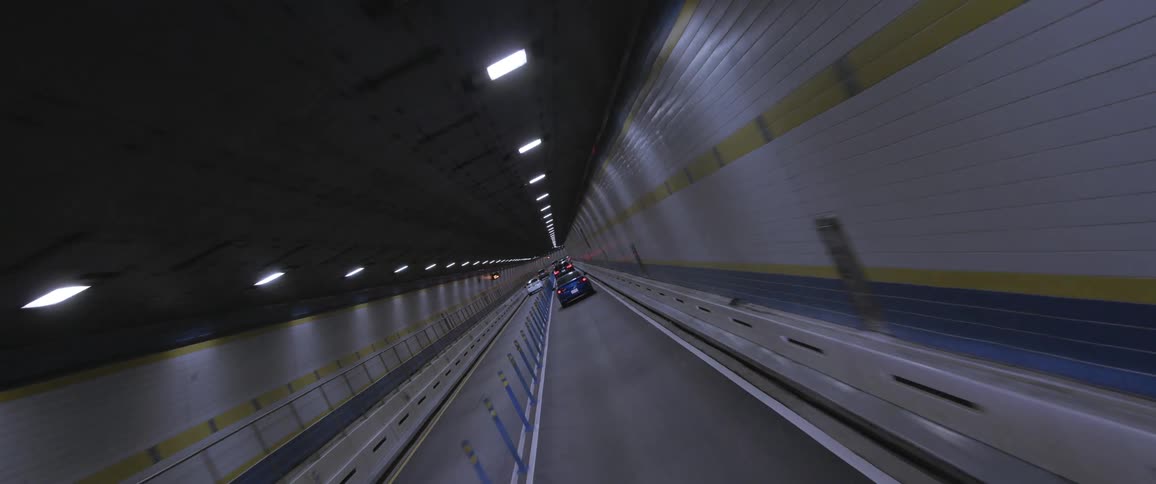 Cars traveling through a city tunnel with tiled walls