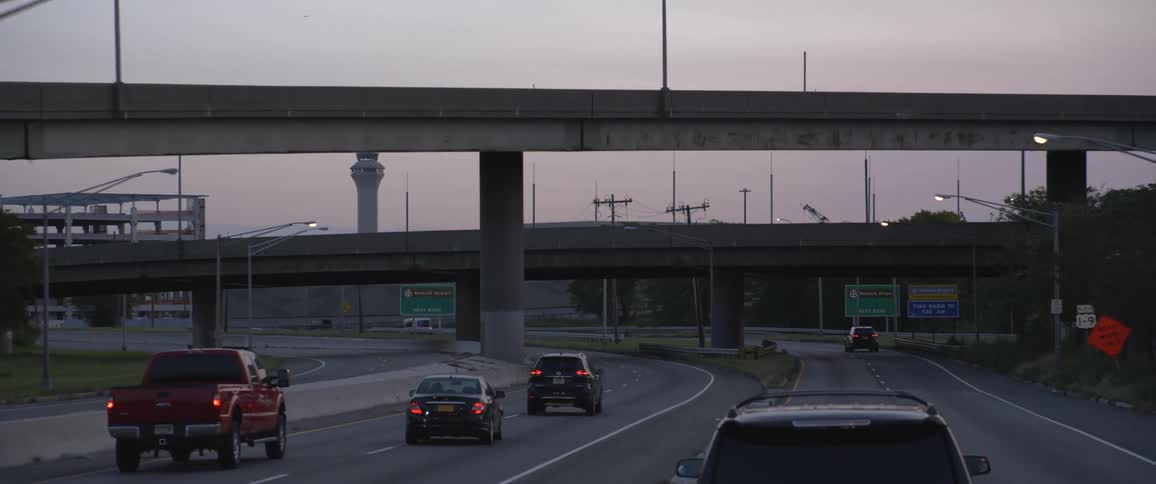 Vehicles drivingon a highway under overpasses and bridges at evening