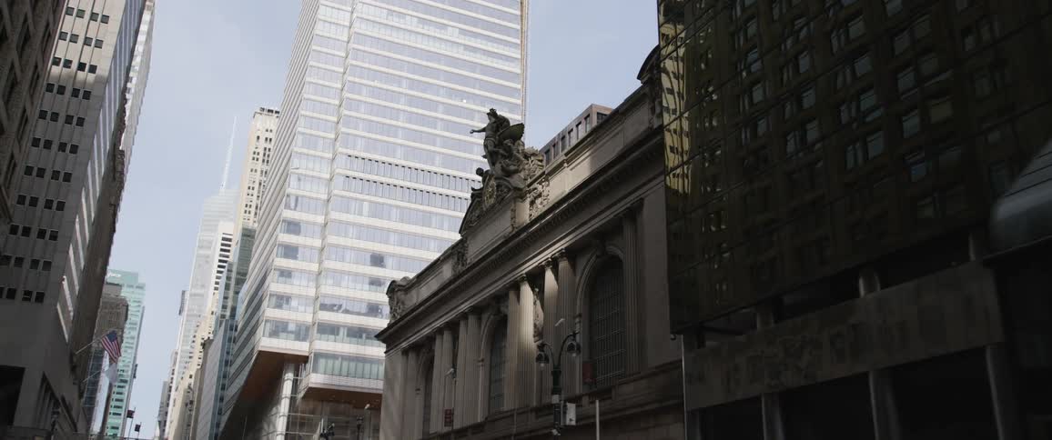 High rise buildings enclosed in a downtown urban area next to a street at daytime